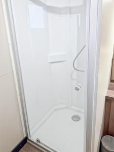 a shower in a small bathroom with a glass door at Le Nouméa, 4 pers, 3 lits in Saint-Pantaléon-de-Lapleau