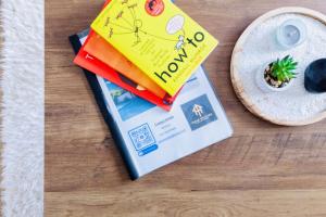 un libro sentado en una mesa junto a un plato en Comfy 3 Bed House by Manchester Airport, Perfect for Groups & Families, en Mánchester
