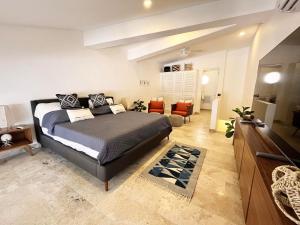 a bedroom with a bed and a living room at Beachside Tranquility Condo in Cozumel