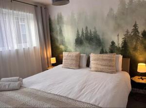 a bedroom with a white bed with a painting on the wall at St Joseph's Guest House in Southampton