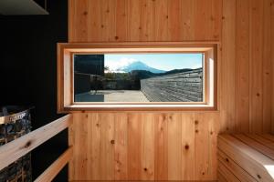 a window in a wooden room with a mountain view at 富士山望むプライベートヴィラ 900平方メートルの敷地を貸切利用 憩 ikoi Fuji サウナ 4Kシアター in Fujikawaguchiko