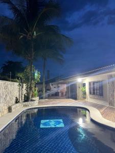 a swimming pool in front of a house at night at Casa de praia Peruibe in Peruíbe