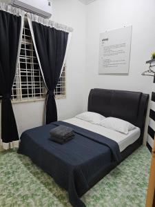 a bedroom with a bed with a blue blanket at Mumtaz Beach Homestay in Dungun