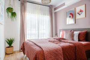 ein Schlafzimmer mit einem Bett mit einer roten Decke und einem Fenster in der Unterkunft Charming Meets Modern Comfort - T2 Apartment in Ferragudo