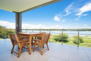 a table and chairs on a balcony with a view of the water at Sandpiper Villas Chobe in Kasane