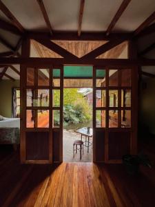 a room with large glass doors and a table at Cabañita del Bambú, en Santa Maria de Dota in Higueronal