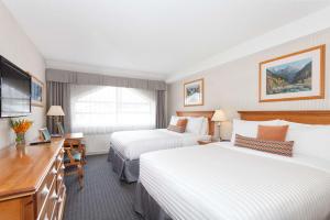 a hotel room with two beds and a television at Listel Whistler, a Coast Hotel in Whistler