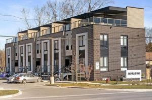 尼亚加拉瀑布Niagara Luxe Suite, 4min to Falls With Fireplace, Ping Pong的一座大型砖砌建筑,前面有一辆汽车