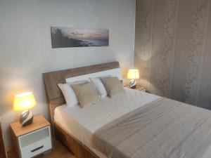 a bedroom with a large bed with two lamps at brISA in Praia
