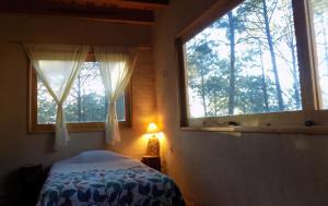a bedroom with a bed and a window and a lamp at Cabaña Ana Paula, Mazamitla, Jalisco in Mazamitla +30 photos