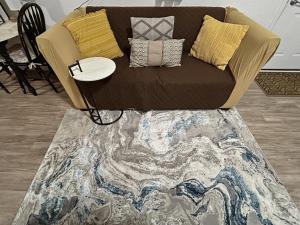 a brown couch with pillows on top of a rug at Quaint Monument Retreat studio in Grand Junction