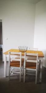 a wooden table with two chairs and a basket on top at Saint-Chéron - superbe appartement lumineux in Saint-Chéron