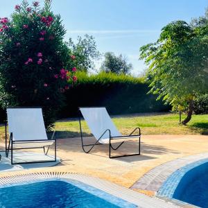 zwei Stühle neben einem Swimmingpool in der Unterkunft Olive Villa in Alcantarilha
