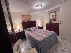 a bedroom with a bed and a dresser and a mirror at A casa do teléfono in Pumares