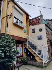 a building with a staircase on the side of it at A casa do teléfono in Pumares
