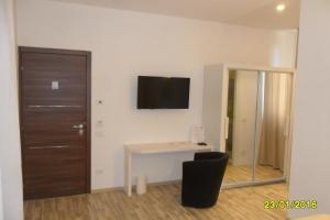 a room with a desk and a television on the wall at Location Lory in Busto Arsizio
