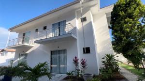 ein weißes Gebäude mit Pflanzen davor in der Unterkunft Casa céu de estrelas in Arraial d'Ajuda