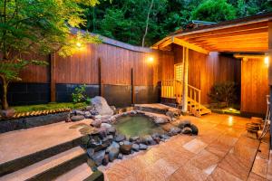 a backyard with a hot tub and a fire pit at Beppu Showaen in Beppu +44 photos