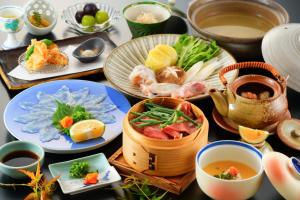 a table topped with plates of food and cups of tea at Beppu Showaen in Beppu