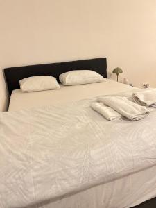 a white bed with white sheets and pillows on it at Brussels City Chambers in Brussels