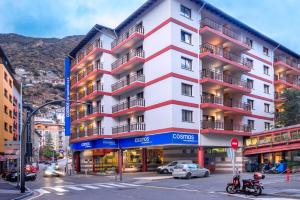 a tall white building with balconies on a city street at Hotel & Aparthotel Cosmos in Andorra la Vella