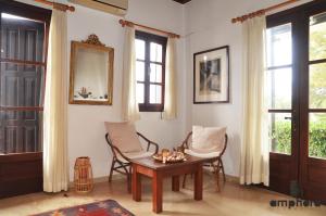 a living room with a table and chairs and windows at Amphora Sea View Pefkos in Pefki Rhodes