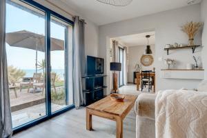 ein Wohnzimmer mit Sofa und Tisch in der Unterkunft A Stalla - Maison pieds dans l'eau à Lucciana in Lucciana