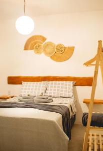 ein Schlafzimmer mit einem Bett mit Hüten an der Wand in der Unterkunft Vila Malie milagres in São Miguel dos Milagres