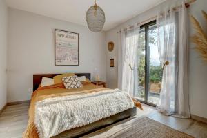 ein Schlafzimmer mit einem Bett und einem großen Fenster in der Unterkunft A Stalla - Maison pieds dans l'eau à Lucciana in Lucciana