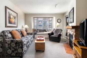 a living room with a couch and a fireplace at Town Plaza Suites by Golden Dreams in Whistler