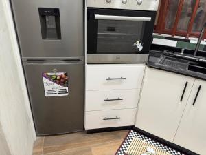 a kitchen with a refrigerator with a bowl of fruit at Luxury Studio in Lomé