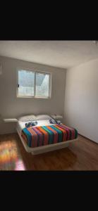 une chambre avec un lit dans une pièce avec une fenêtre dans l'établissement La Casa De La Abuela, à Zihuatanejo