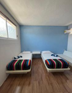 Ce lit se trouve dans un dortoir doté de murs bleus et de parquet. dans l'établissement La Casa De La Abuela, à Zihuatanejo