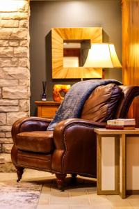 a brown leather couch in a living room with a table at TU CASA-pooltable-playset-sauna in Willmar