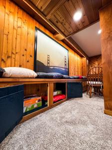a room with a large tv on a wooden wall at TU CASA-pooltable-playset-sauna in Willmar