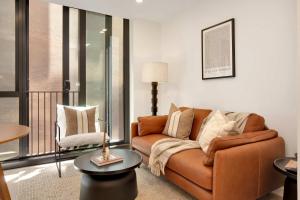 a living room with a couch and a table at Perfectly Paired - Your Dual Apartment Escape in Wellington