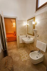a bathroom with a sink and a toilet and a mirror at Le Radici in Uggiano la Chiesa +38 photos