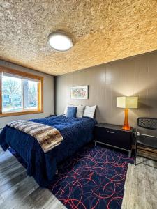 a bedroom with a bed with a blue comforter and a carpet at MY FLAT! Industrial 3 Bd with outdoor space! in Willmar