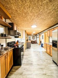 a large kitchen with wooden cabinets and appliances at MY FLAT! Industrial 3 Bd with outdoor space! in Willmar