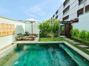 a swimming pool in front of a building at Sejati Villas - Petitenget in Seminyak