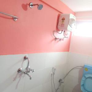 a bathroom with a blue toilet and a pink wall at Khaling Homestay in Darjeeling