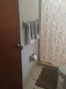 a bathroom with a toilet and a door with towels at COZUMEL-1 Bed 1 Ba PARADISE in Cozumel