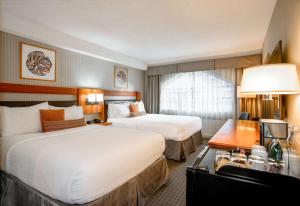 a hotel room with two beds and a desk at Listel Whistler, a Coast Hotel in Whistler