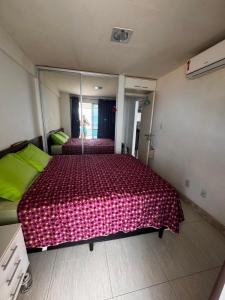 a bedroom with a large bed and a large mirror at Apartamento Ondina Salvador in Salvador +14 photos