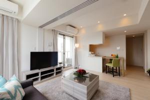 東京にあるOakwood Apartments Minami Azabu Tokyoの大型薄型テレビのあるリビングルーム