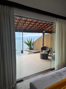 a bedroom with a balcony with a view of the ocean at Casa da Ilha in Praia de Araçatiba +101 photos