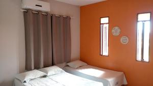 a room with two beds and two windows at Pousada Lunar in Parnaíba