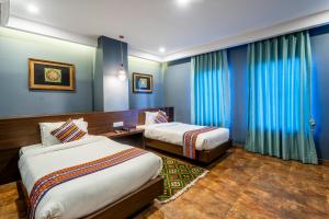 a hotel room with two beds and blue walls at Hotel Yukhang in Kathmandu