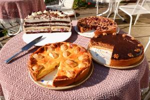 drei Kuchen auf einem Tisch mit Tischtuch in der Unterkunft Café Pension Waldfrieden in Bad Peterstal-Griesbach