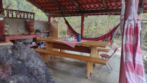 a picnic table and a hammock in a tent at Chácara Morro da Pedra in Cavalcante